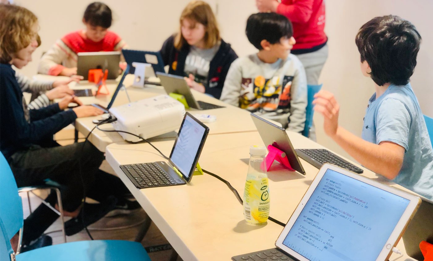 Enfants intermédiaires apprenant la programmation en groupe